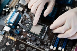 s hand insert processor cpu chip in the socket of motherboard, computer assembly process