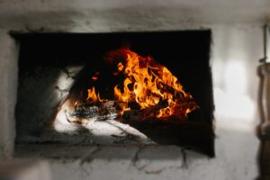 Ukrainian traditional oven in the house. Firewood is burning in the oven, baking bread.